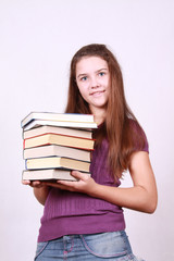 Schoolgirl keeps in hand pile books