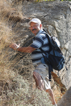 Mature Man Climbing On Rock