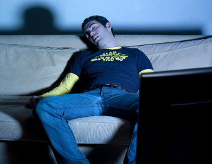 jeune homme dormir télévision obscurité - obrazy, fototapety, plakaty