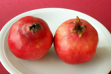 organic and healthy pomegranate on a white plate