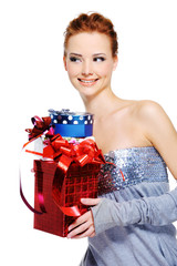 Cute cheerful femlae holding the christmas present boxes