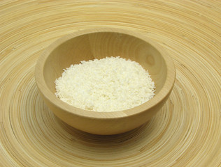Holzschale mit Kokosflocken auf Bambusteller