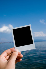 Photo in a hand on nature sea background