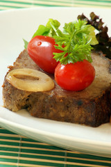 sliced meat loaf with organic parsley on a plate