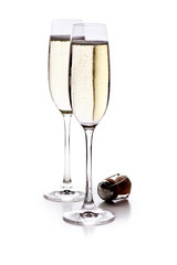 Zwei Gläser Sekt mit Korken auf weißem Hintergrund