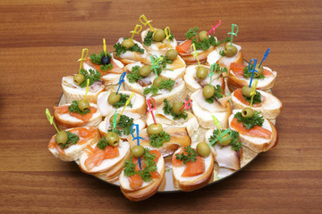 Open sandwiches with red and white fish, olives and greens