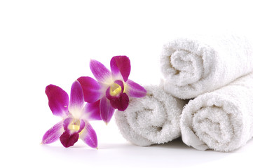 Fototapeta na wymiar Biały zwinięty ręcznik z różowa orchidea