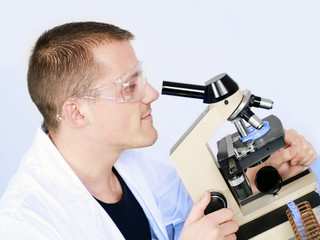 smiling man researching on a microscope
