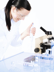 smiling brunette medical woman researching on a microscope