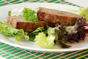 sliced meat loaf with organic vegetable on a plate