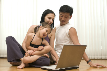 Happy young family, fanny working with laptop indoor