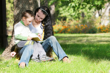 Fototapeta premium mother and son reading book in park