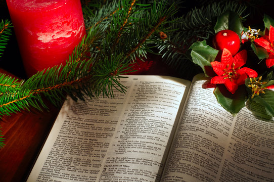 Bible open to Luke 2 Christmas text amid Christmas decor