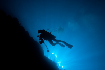 Silhouette of an underwater photographer