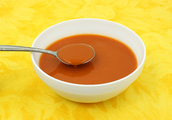 Tomato soup in white bowl with spoon