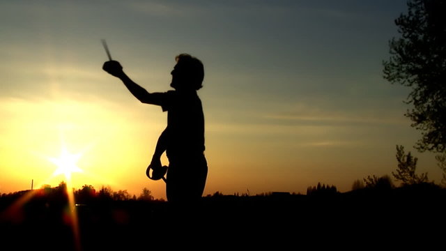 Man at sunset moving with sword