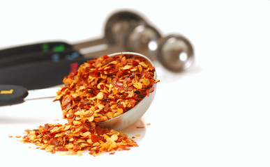 Red pepper flakes in a measuring spoon