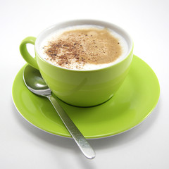Cappuccino in green cup with spoon &ndash; coffee break and lifestyle concept