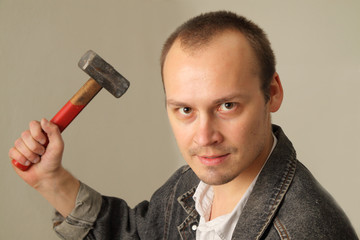 Angry, aggressive man with a big hammer