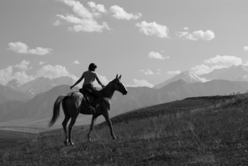 Fototapeta na wymiar Girl riding a horse in the mountains