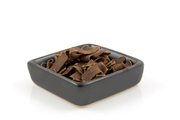 bowl with Dutch chocolate flakes over white background