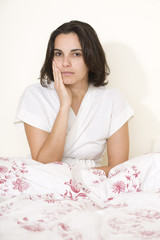 Obraz na płótnie Canvas Junge hübsche Frau mit Zahnschmerzen im Bett