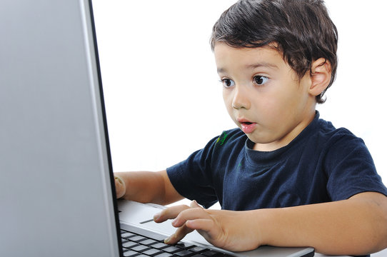 A little cute kid with a laptop isolated, shocked face