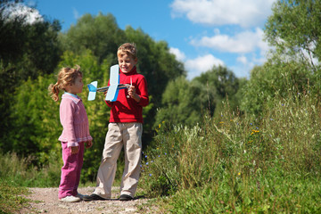 Obraz premium little girl and boy with toy airplane in hands outdoor