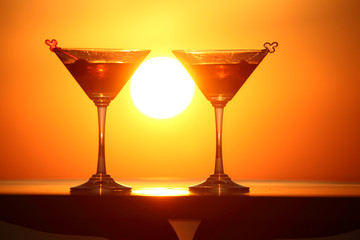 two glasses of wine on table on sunset