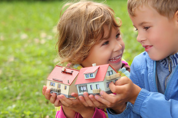 children  with toy small houses in hands outdoor