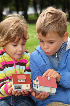 children  with toy small houses in hands outdoor