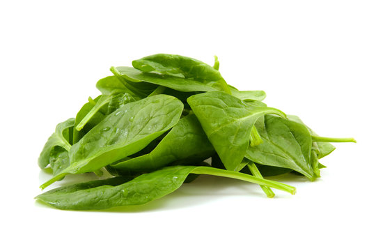 stacked fresh spinach over white background