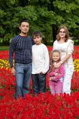 family of four persons in flowering park