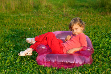 young model sits in inflatable armchair outdoors