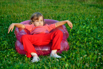 Fototapeta premium girl looking aside in inflatable armchair