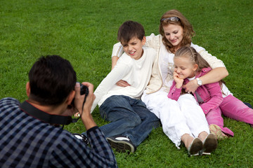 man photographes his family outdoors