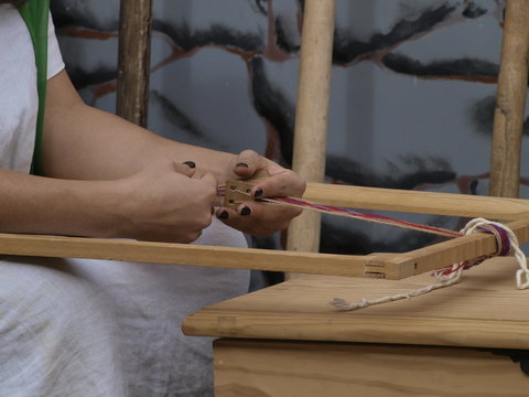 Manos de mujer romana tejiendo