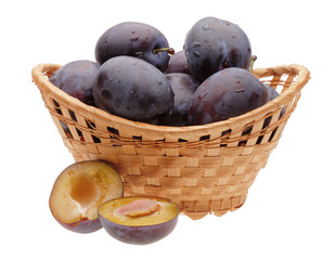 plums in basket and cut plum on white background