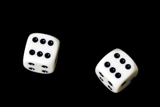 Two dice showing six on a black background