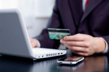 Businessman using his credit card for an online transaction