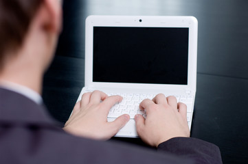 Businessman typing on his notebook. Above the shoulder view.