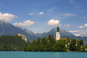 Fototapeta na wymiar Bled lake, island, castle, church and mountains in background