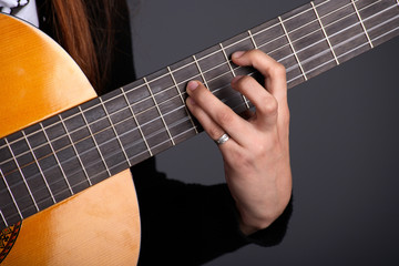Fototapeta na wymiar Close up of female guitarist hand playing guitar