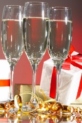 Glasses of champagne, gifts with red tapes and bows