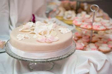 Wedding cake with pink icing decorated with rose petals