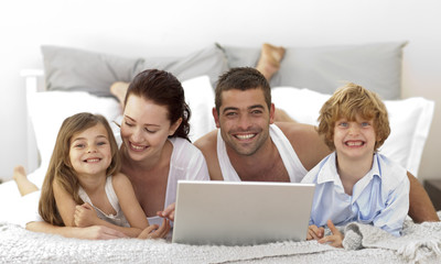Fototapeta premium Family in bed using a laptop
