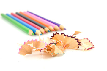 Colorful pencils and shavings over white background