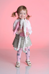 Little girl is playing with rabbit toy in studio