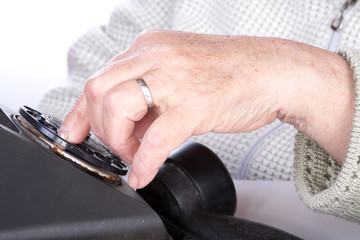 The hand  old woman dials  number of phone