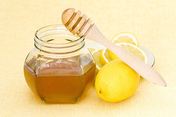 jar of honey, lemon and wooden drizzler